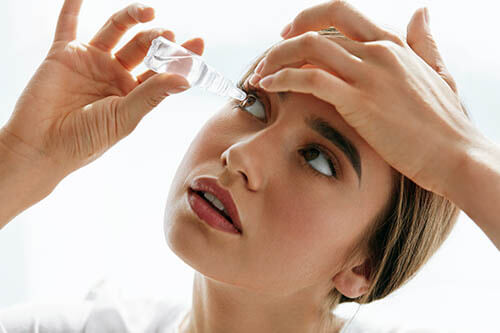 Woman Putting Eye Drops Into Her Eye